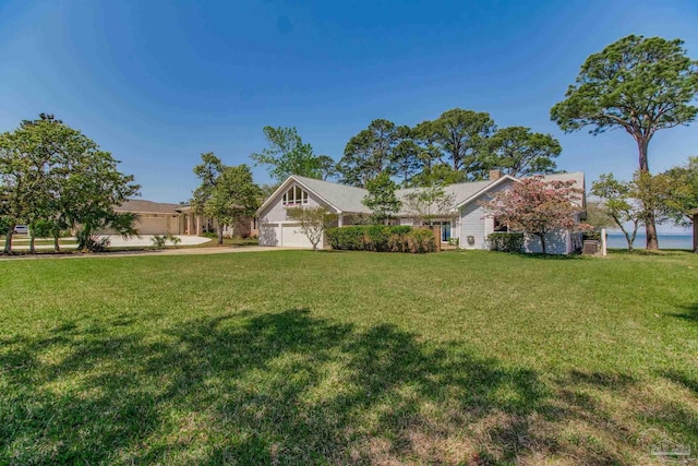 view of yard with a garage and concrete driveway