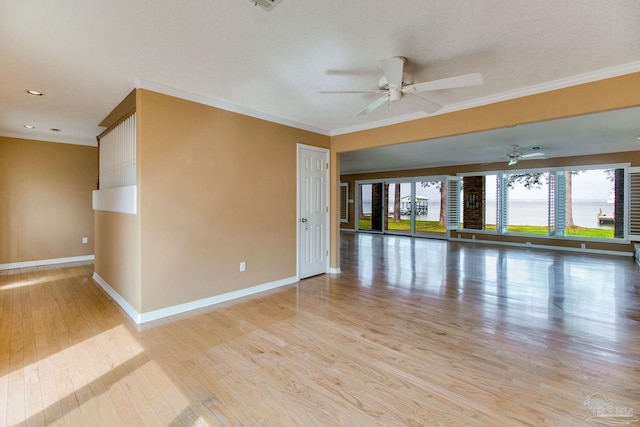 spare room featuring crown molding, baseboards, and ceiling fan