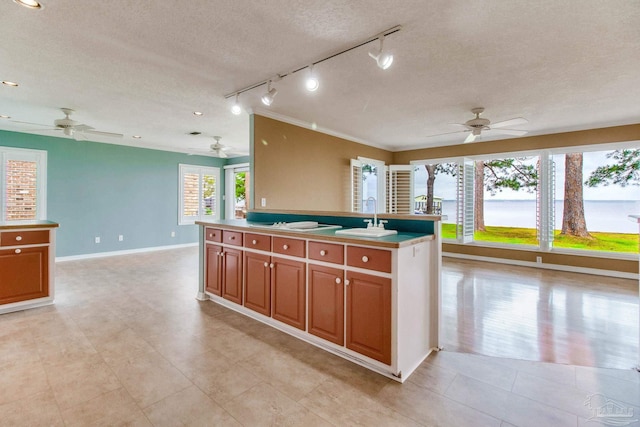 kitchen featuring track lighting, a ceiling fan, a textured ceiling, and open floor plan