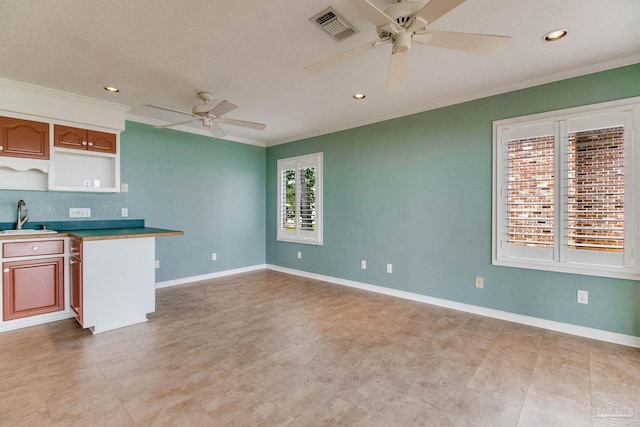 kitchen featuring a ceiling fan, visible vents, crown molding, a sink, and recessed lighting