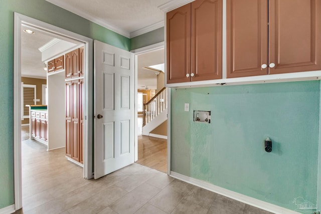 washroom with crown molding, baseboards, electric dryer hookup, cabinet space, and washer hookup