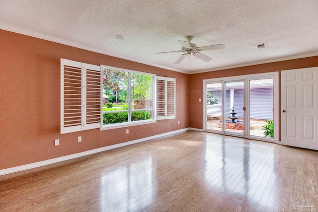 empty room featuring ornamental molding, a textured ceiling, and visible vents