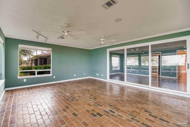 spare room featuring visible vents, ornamental molding, a textured ceiling, and a ceiling fan
