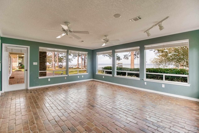 unfurnished sunroom featuring visible vents and track lighting