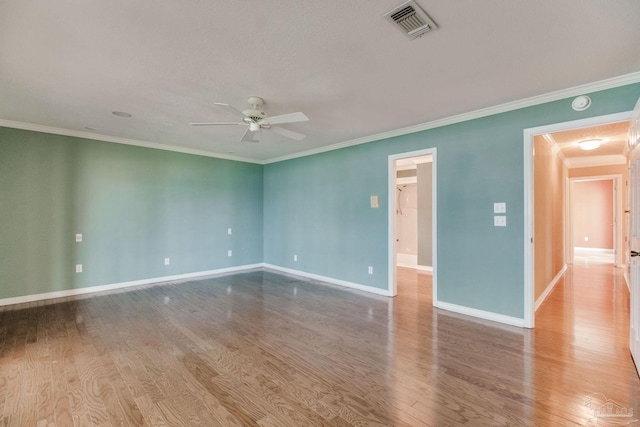 unfurnished room featuring crown molding, a ceiling fan, baseboards, wood finished floors, and visible vents