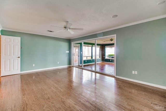 spare room with visible vents, crown molding, ceiling fan, and wood finished floors