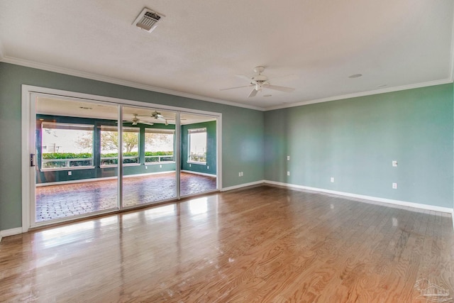 spare room featuring crown molding, baseboards, a ceiling fan, and visible vents