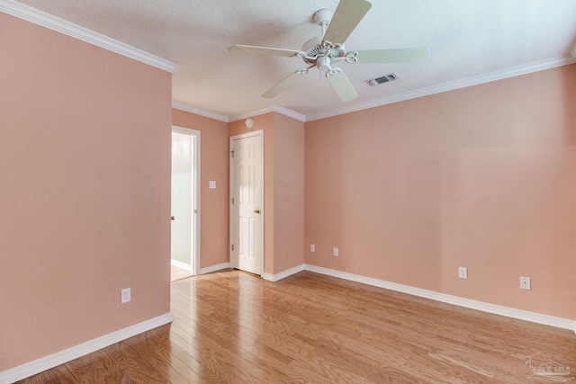 empty room with visible vents, crown molding, baseboards, ceiling fan, and light wood finished floors