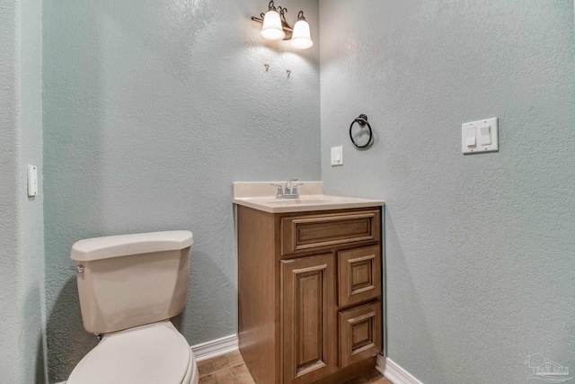 bathroom with vanity, baseboards, and toilet