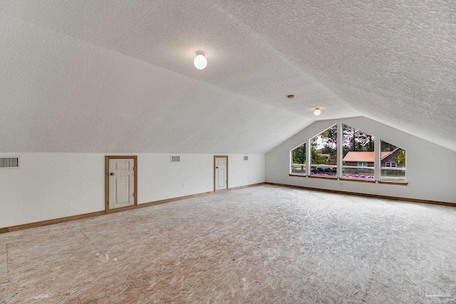 bonus room featuring visible vents, carpet floors, a textured ceiling, baseboards, and vaulted ceiling