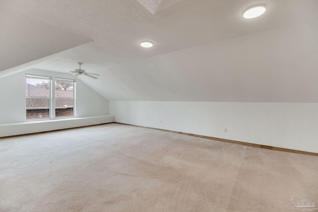 bonus room featuring a ceiling fan, baseboards, light carpet, and vaulted ceiling