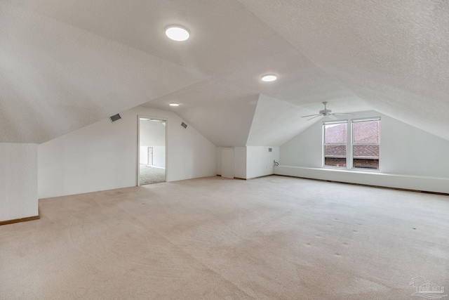 bonus room with carpet floors, visible vents, ceiling fan, and lofted ceiling