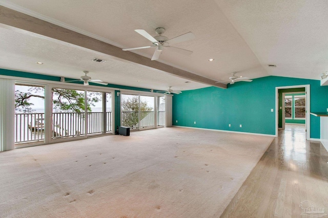 interior space featuring baseboards, a ceiling fan, a textured ceiling, and visible vents