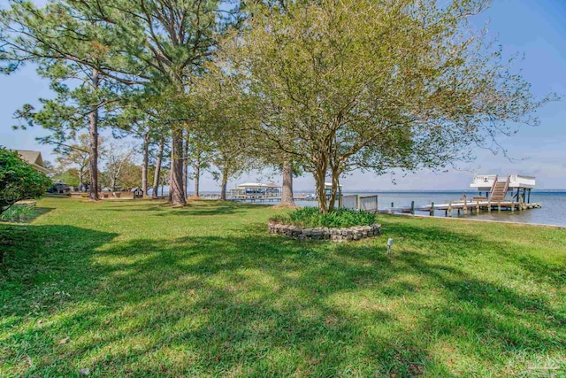 view of yard featuring a water view, boat lift, and a dock