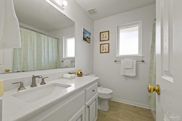 bathroom with wood-type flooring, toilet, and vanity