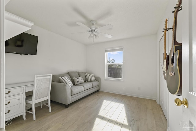 office featuring ceiling fan, built in desk, and light wood-type flooring