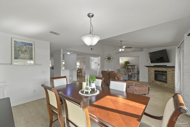 dining space featuring ceiling fan, vaulted ceiling, and light wood-type flooring