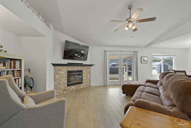 living room with french doors, vaulted ceiling, light hardwood / wood-style flooring, a textured ceiling, and ceiling fan