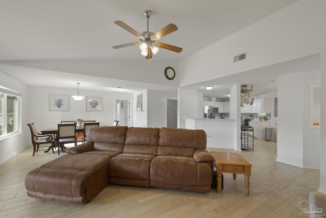 living room with vaulted ceiling, light hardwood / wood-style floors, and ceiling fan