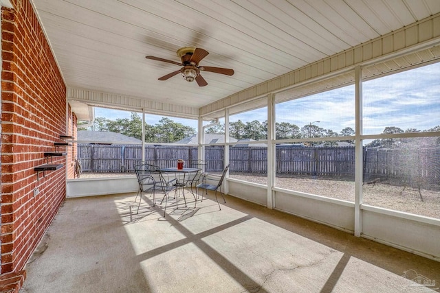 unfurnished sunroom featuring ceiling fan