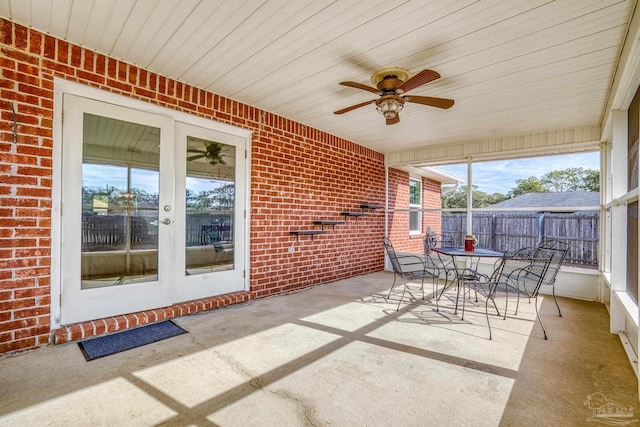 unfurnished sunroom featuring wood ceiling and ceiling fan