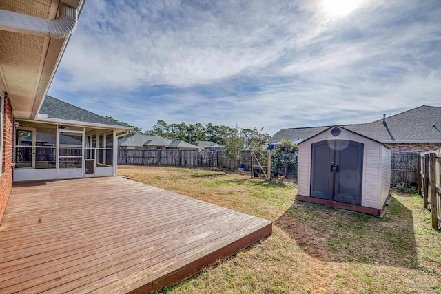 view of yard with a wooden deck, a storage shed, and a sunroom