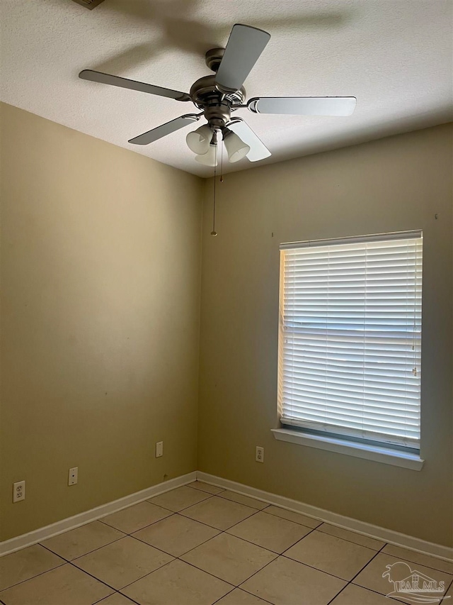 unfurnished room featuring a textured ceiling, light tile patterned flooring, and ceiling fan