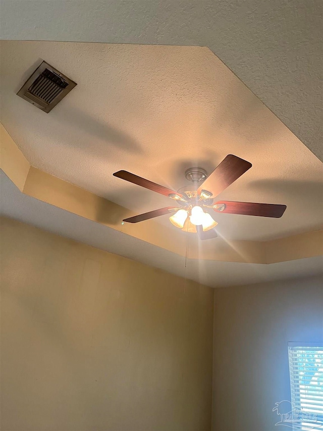 room details with ceiling fan and a textured ceiling