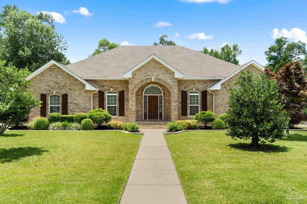 8821 Marsh Elder Dr, Pensacola, FL 32526 - view of front facade featuring brick siding, a front yard, and roof with shingles