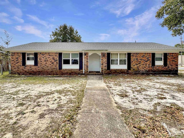 single story home with a shingled roof, brick siding, and fence