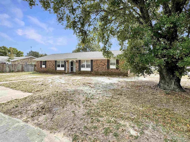 ranch-style house featuring fence and brick siding