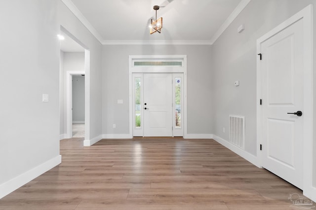 foyer with crown molding and light hardwood / wood-style floors