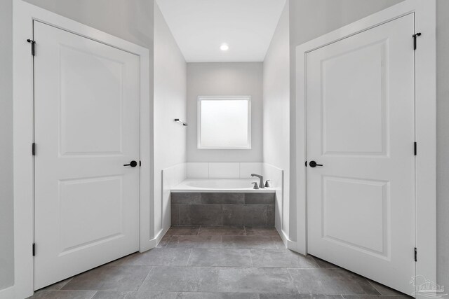 bathroom featuring a relaxing tiled tub