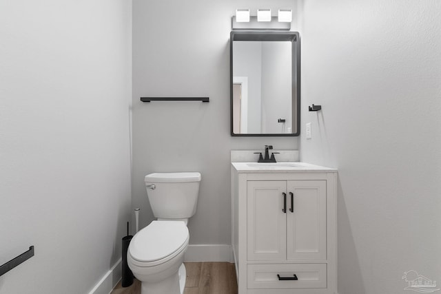 bathroom with vanity, wood-type flooring, and toilet