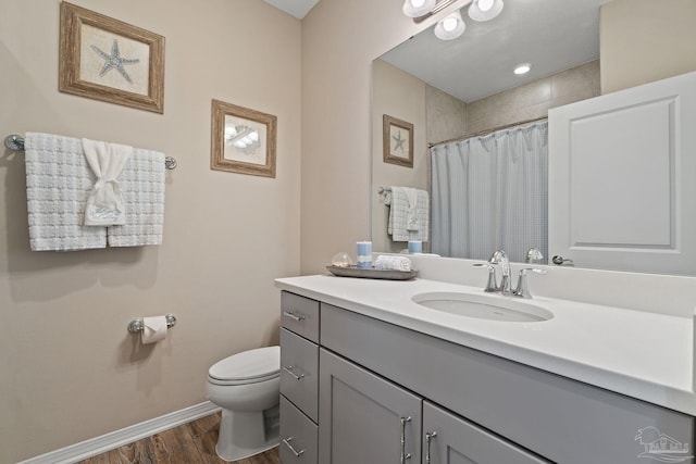 bathroom with a shower with shower curtain, wood-type flooring, vanity, and toilet