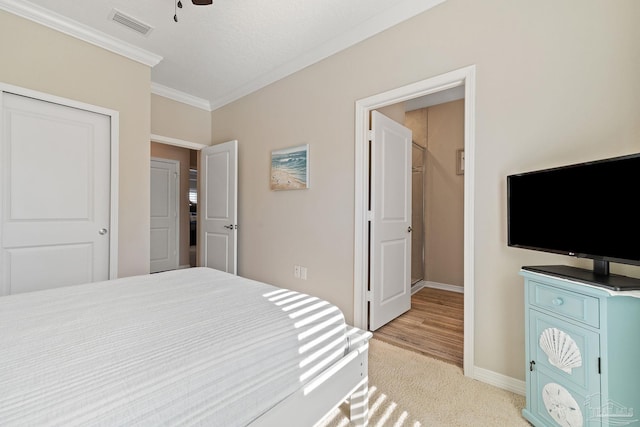 carpeted bedroom with ceiling fan, ornamental molding, and a closet