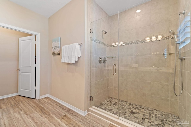 bathroom with wood-type flooring and an enclosed shower