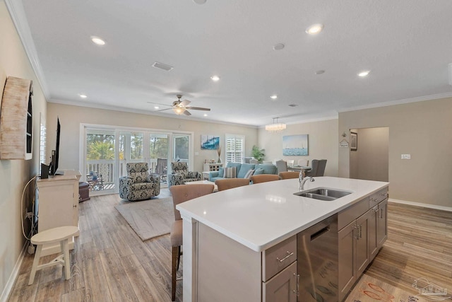 kitchen featuring a wealth of natural light, sink, stainless steel dishwasher, an island with sink, and ceiling fan with notable chandelier