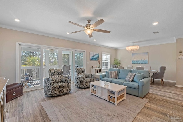 living room with a textured ceiling, light hardwood / wood-style flooring, and ceiling fan with notable chandelier