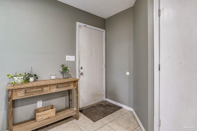 entryway with a textured ceiling and light tile patterned floors