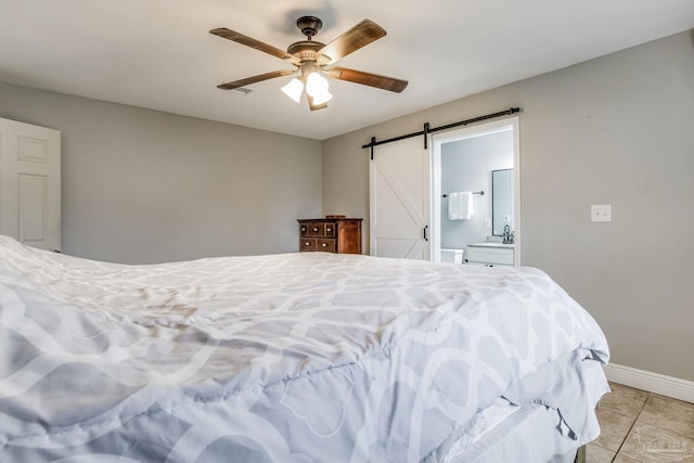 tiled bedroom with connected bathroom, ceiling fan, and a barn door