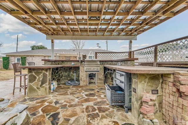 view of patio / terrace with a grill, exterior kitchen, and an outdoor bar