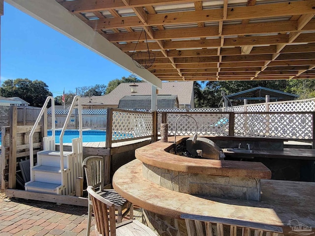 view of patio / terrace with an outdoor bar, a fenced in pool, and area for grilling