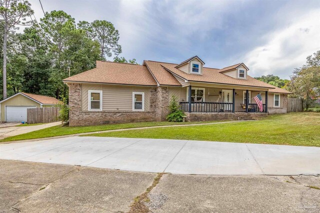 view of front of property with a front lawn, an outdoor structure, a garage, and a porch