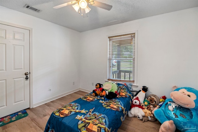 bedroom featuring a textured ceiling, light hardwood / wood-style flooring, and ceiling fan