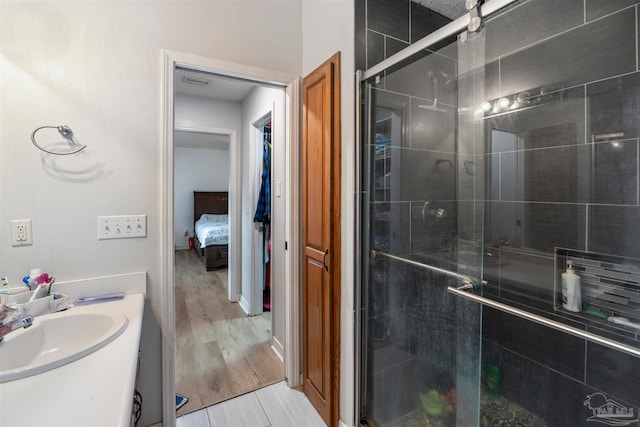 bathroom featuring wood-type flooring, walk in shower, and vanity