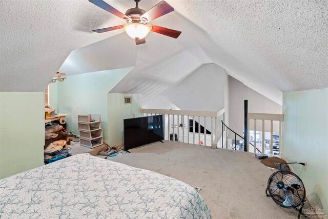 bedroom with a textured ceiling, carpet flooring, vaulted ceiling, and ceiling fan