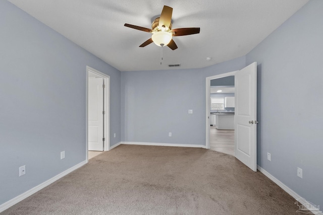 unfurnished bedroom featuring ceiling fan and light colored carpet