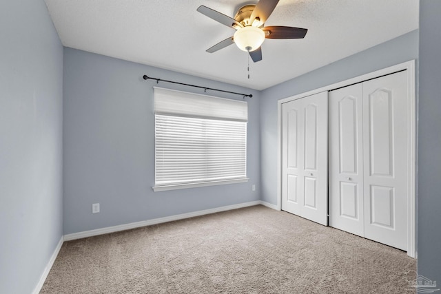 unfurnished bedroom featuring carpet, ceiling fan, and a closet