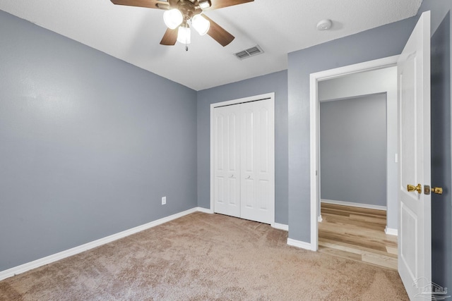 unfurnished bedroom with a closet, carpet floors, and ceiling fan